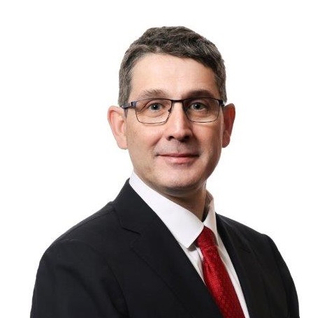 Man in suit with white shirt and red tie